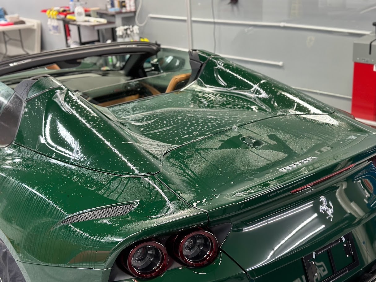 Wet installation of paint protection film on Ferrari 812 Superfast engine cover in Lake Norman