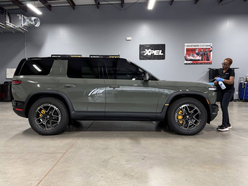 Green Rivian R2 with XPEL ULTIMATE PLUS paint protection film being detailed at Exclusive Paint Protection